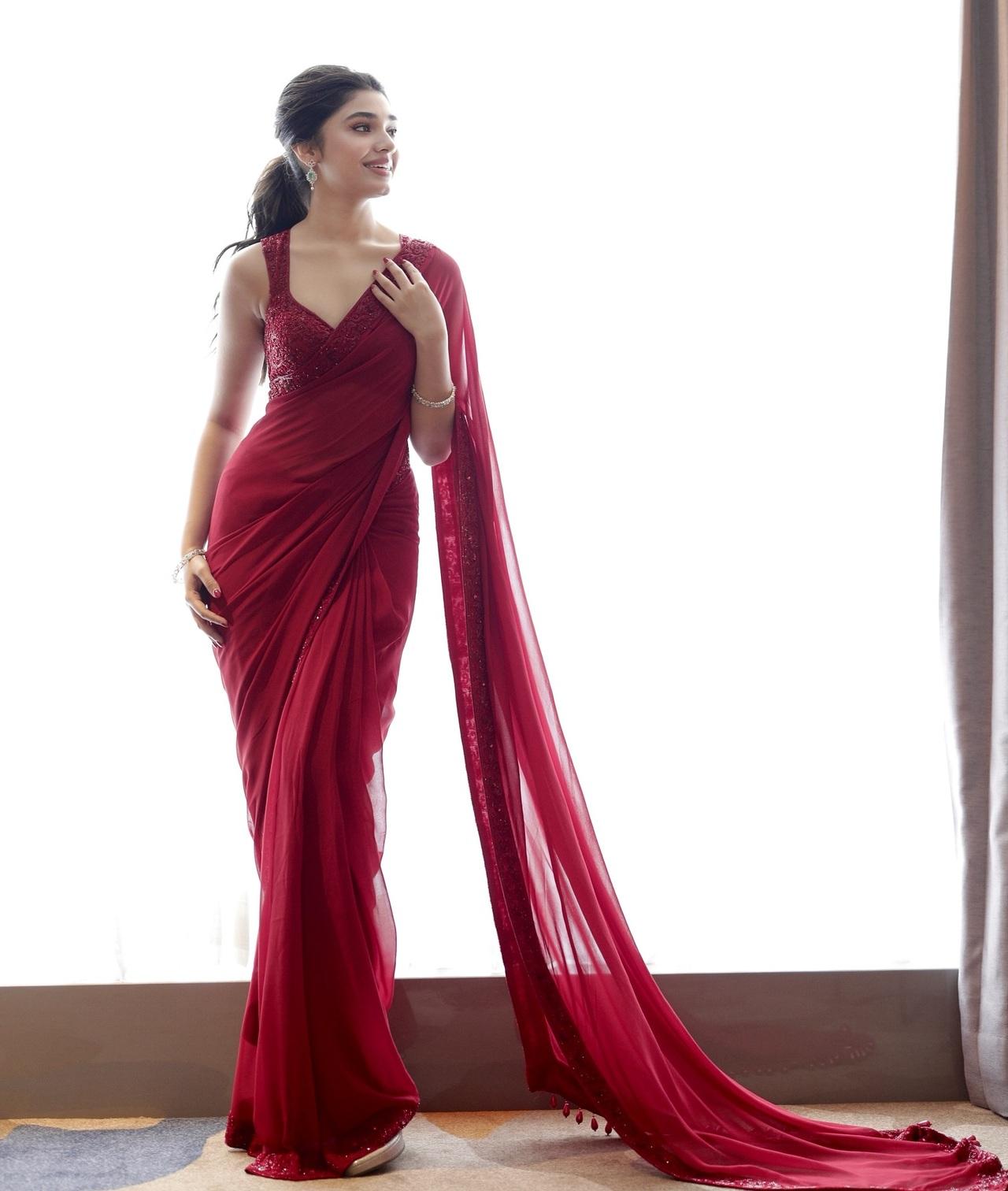 The actress exudes timeless elegance in this deep red saree with an embellished sequin blouse. She opted for a sleek ponytail and minimal diamond jewellery to complete the look. 